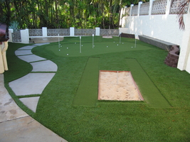 backyard synthetic turf putting green with sand trap and chipping mat